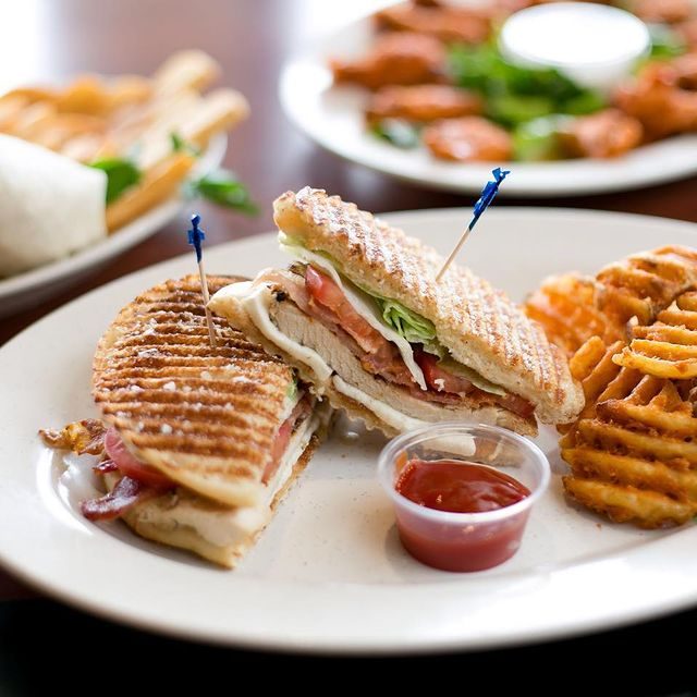 A plate of sandwiches and fries on a table.